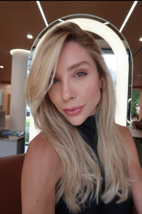 Woman with long blonde hair and soft makeup posing.