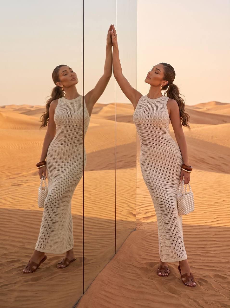 Woman in crochet dress reflecting in a desert mirror.