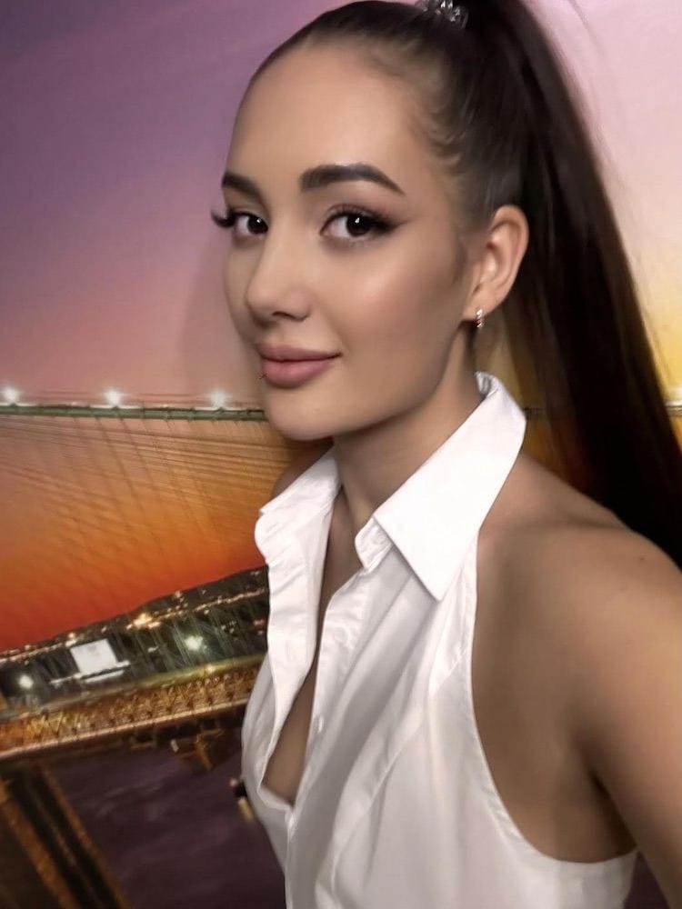 Woman in white halter-neck shirt with high ponytail.