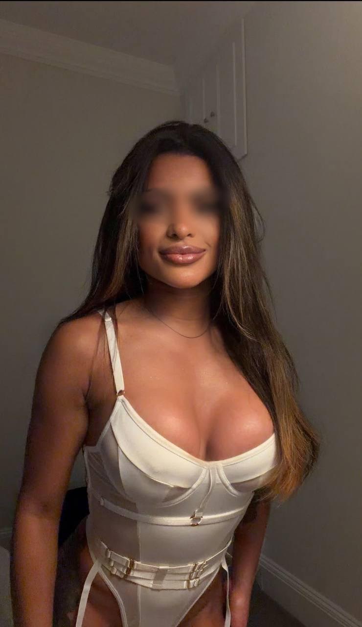 Woman in a white bodysuit posing with long hair.