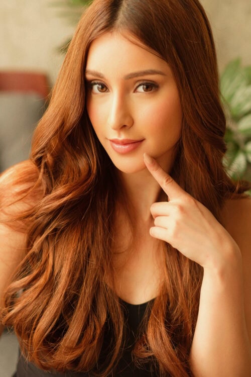 Close-up portrait of a woman with long reddish-brown hair.