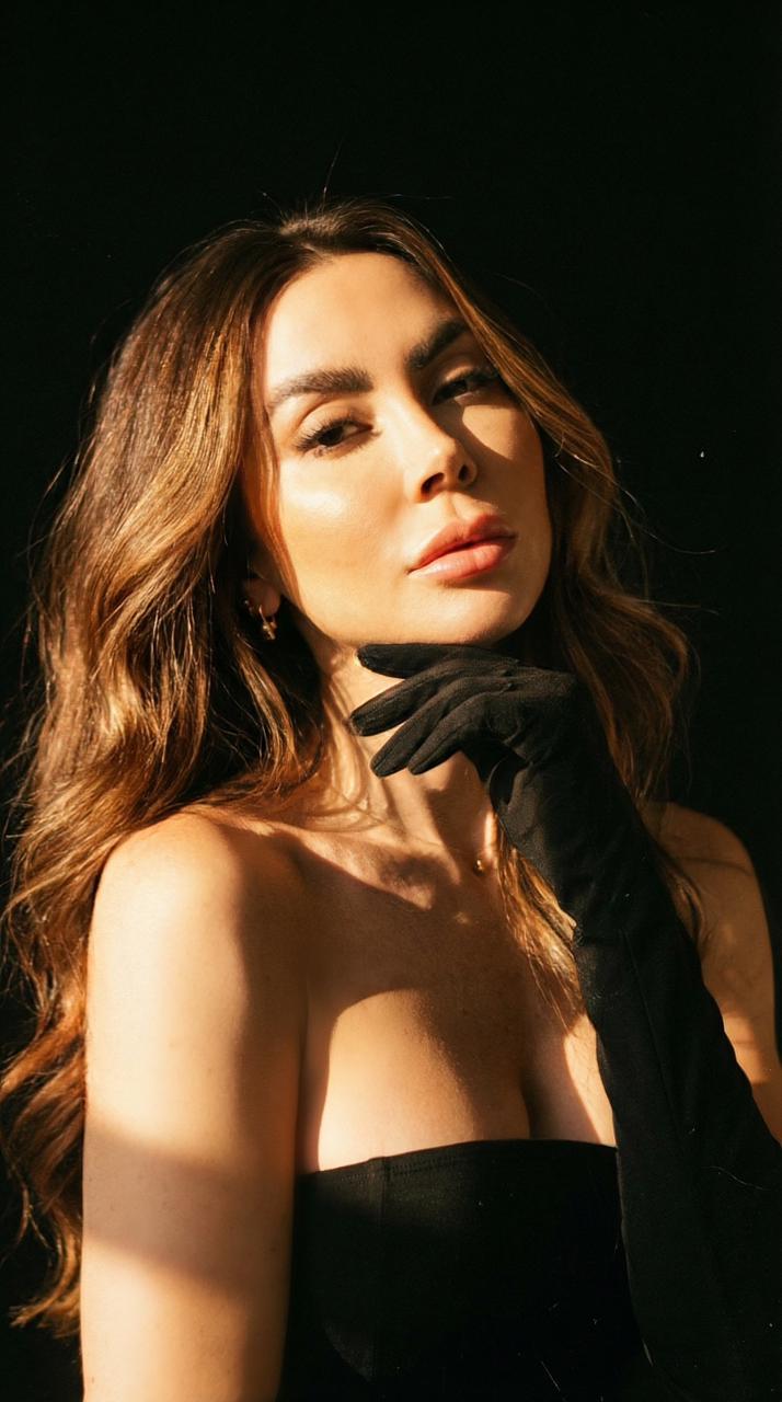Woman in black gloves posing in warm direct sunlight.